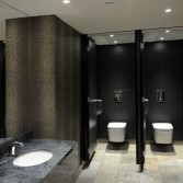 High end washroom area in grey tones, with marble grey vanity top and white basins.