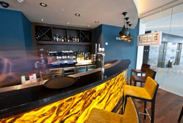 Curved bar with yellow onyx front panel and black bar top