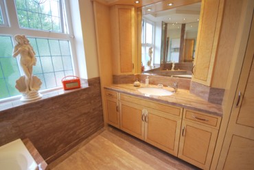 Real wood cabinet with granite vanity top and wall panels.